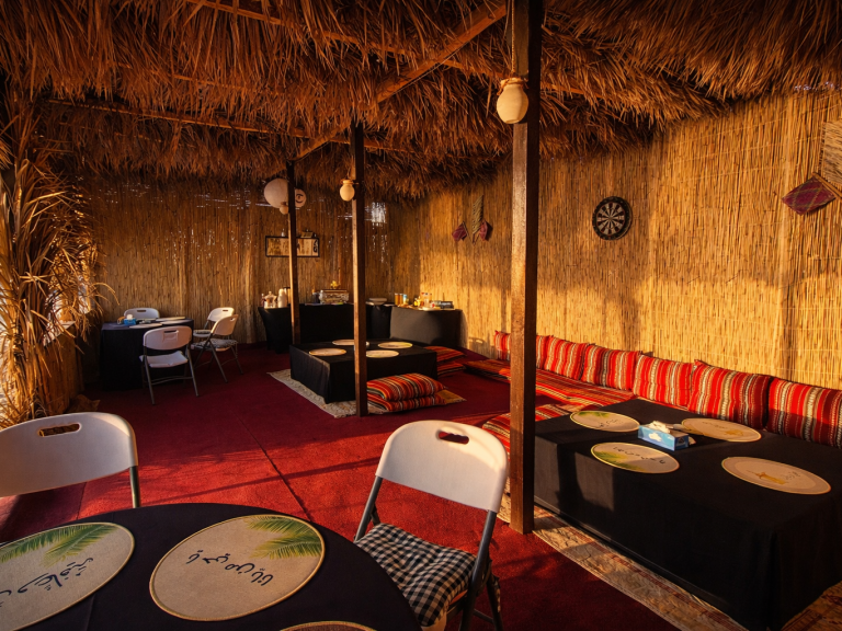 Ocean Camp Traditionally furnished room with carpets, cushions, and a low table.