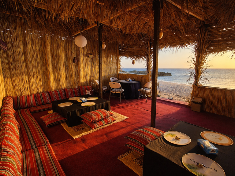 Ocean Camp Traditionally furnished room with carpets, cushions, and a low table.